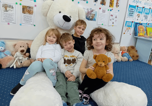 Dzieci z zabawkowym misiem.