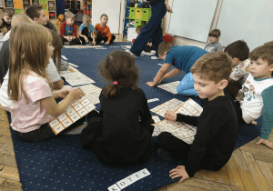 Dzieci układają proste wyrazy z albumu liter.