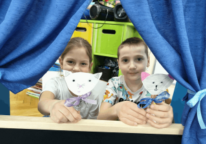 Dzieci pokazują swoje prace plastyczne.