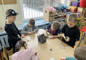 Dzieci wykonują kotka z papieru.