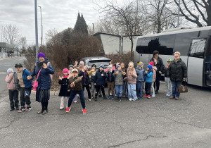 Dzieci wychodzą z autobusu i idą do fabryki leków.