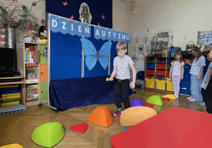 Chłopiec idzie po ścieżce sensorycznej.
