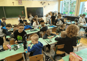 Przedszkolaki wspólnie z uczniami wykonują prace plastyczne.