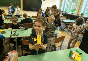 Chłopiec prezentuje wykonaną pracę plastyczną.