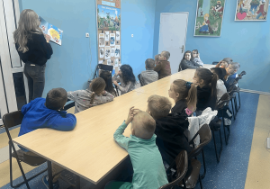 Pani bibliotekarka czyta dzieciom książkę.