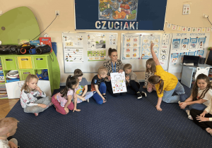 Pani prezentuje pracę wykonaną wspólnie z dziećmi.
