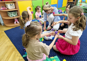 Dziewczynki z dumą prezentują własnoręcznie zrobione, ekologiczne kwiaty.