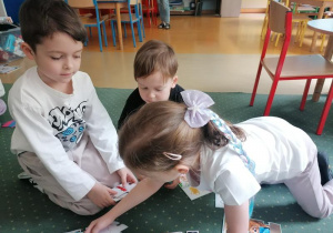 Natalka, Ksawery i Mikołaj rozwiązują obrazkowe zagadki.
