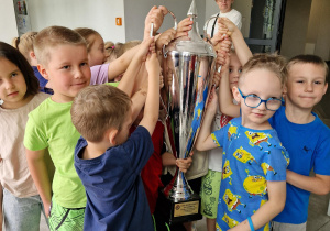 „Biedronki” z bliska oglądają i dotykają prawdziwy, piłkarski puchar.
