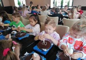 Natalka, Kaja, Apolonia i Mikołaj dekorują swoje torciki.