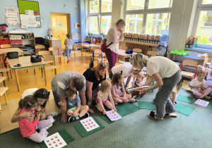 Dzieci liczą kropki biedronkom.