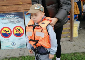 Filip demonstruje jak należy założyć kamizelkę ratunkową.