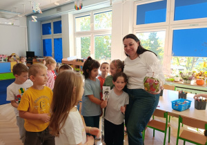 "Biedronki" wręczają pani Anecie upominek.
