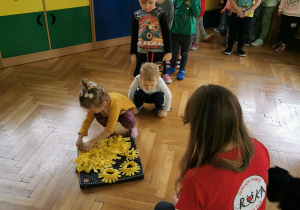 Dzieci ukrywają w macie smakołyki dla Zyty.