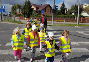 Przedszkolaki przechodzą przez pasy na skrzyżowaniu świetlnym