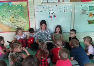 Dzieci słuchają książki czytanej przez mamę Ksawerego